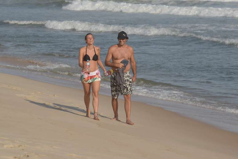 Luciano Szafir caminha na praia com a mulher 