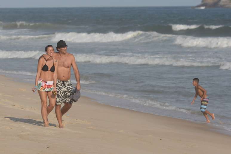 Luciano Szafir caminha na praia com a mulher 