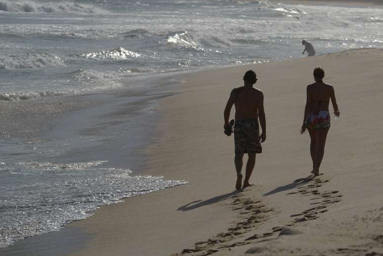 Luciano Szafir caminha na praia com a mulher 