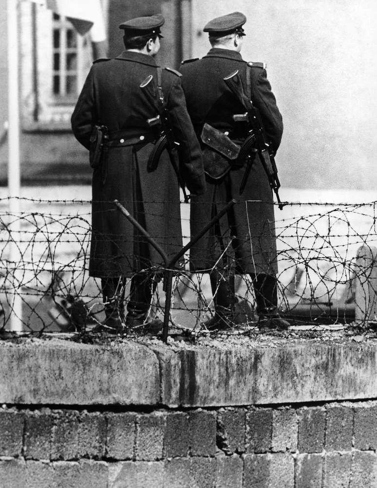 <p>Guardas em frente ao muro de&nbsp;Berlim, Alemanha, em 7 de agosto de 1964&nbsp;</p>