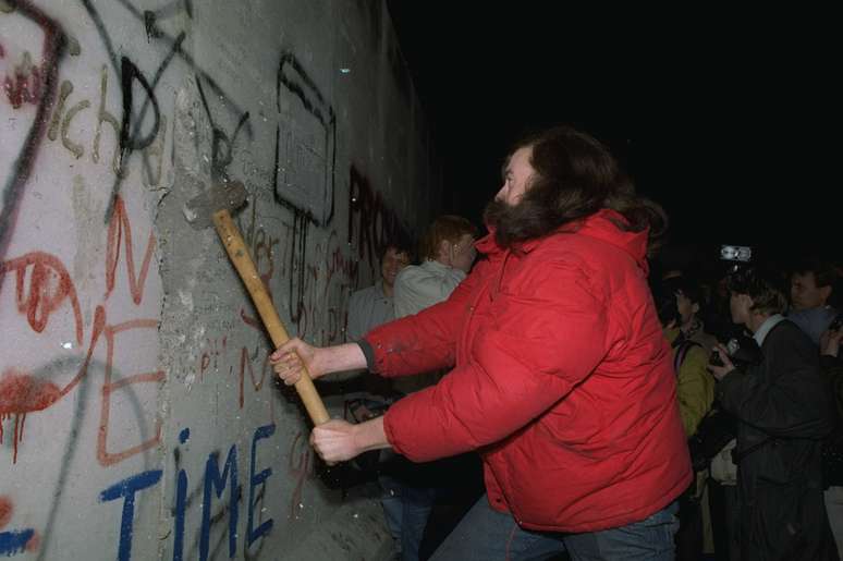 <p>Berlinense usa uma marreta para "destruir" o Muro de Berlim em, 11 de novembro de 1989</p>