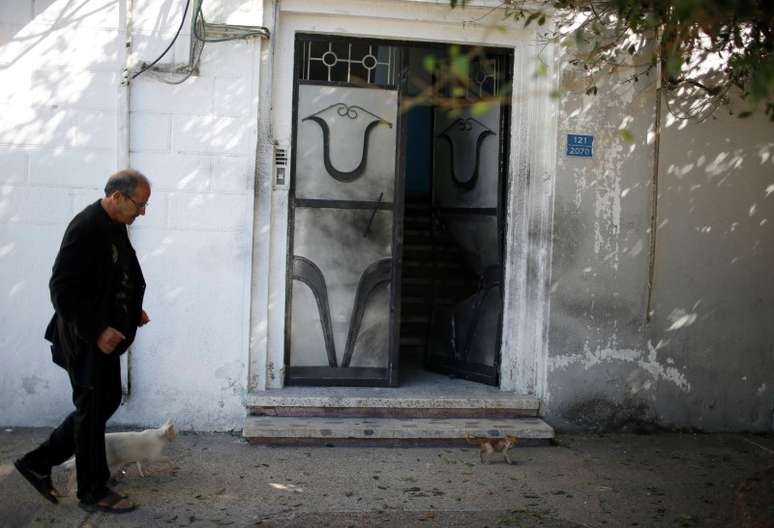<p>Homem passa em frente a&nbsp;moradias de dirigentes do Fatah em Gaza, ap&oacute;s explos&otilde;es na &uacute;ltima sexta-feira</p>