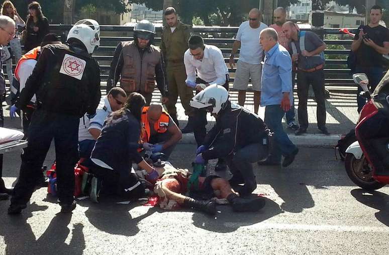 <p>M&eacute;dicos israelenses atendem o&nbsp;soldado esfaqueado em Tel Aviv, em Israel, nesta segunda-feira</p>