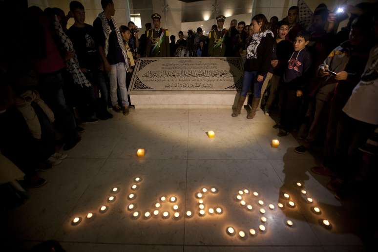 <p>Palestinos acendem velas no t&uacute;mulo do l&iacute;der palestino Yasser Arafat, marcando o 10&ordm; anivers&aacute;rio da sua morte, na cidade de Ramallah, Cisjord&acirc;nia. No ch&atilde;o, &eacute; poss&iacute;vel ler&nbsp;"Abu Ammar",&nbsp;nome de guerra de&nbsp;Arafat&nbsp;</p>