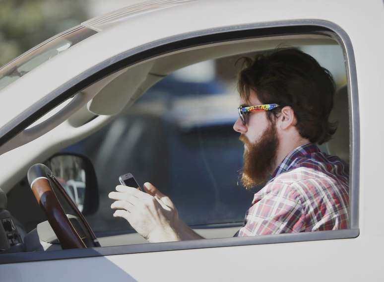 Un hombre usa su teléfono celular mientras conduce en Dallas, Texas, en foto de archivo del 26 de febrero de 2013.