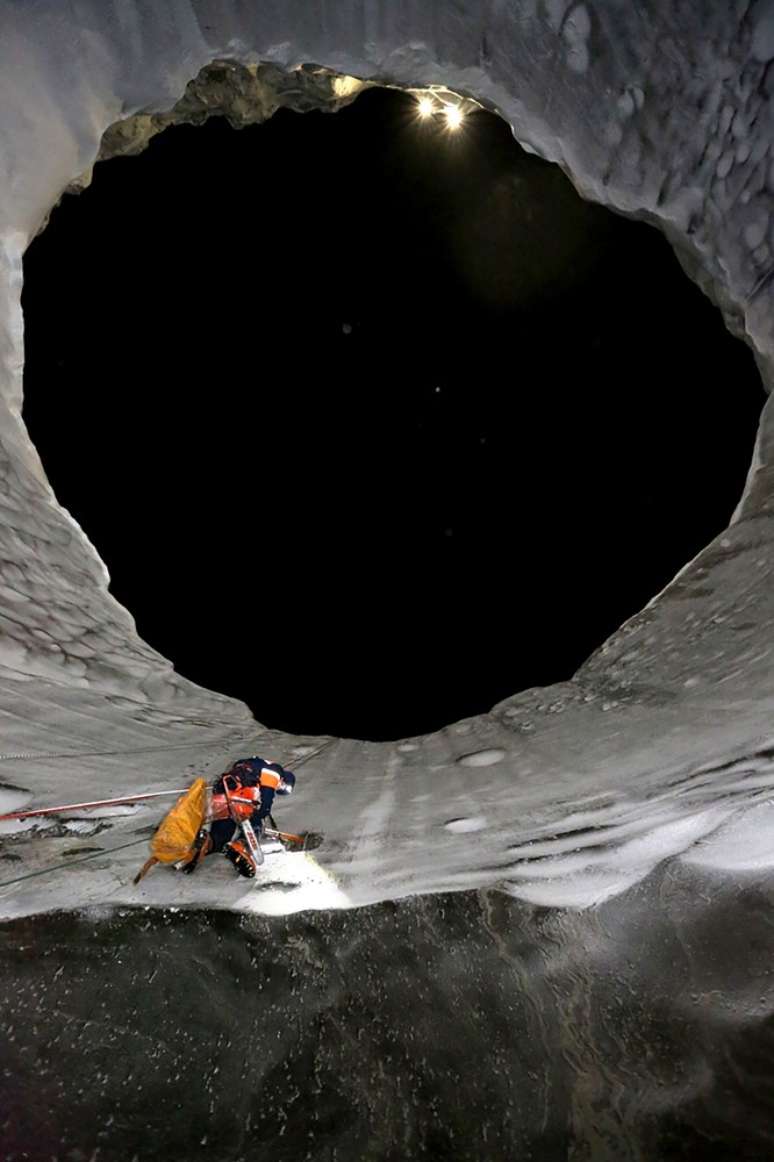 Os pesquisadores, então, estão praticando rapel na cratera de mais de 15 metros de profundidade sob temperatura de  11 C, para chegar ao lago congelado em sua base