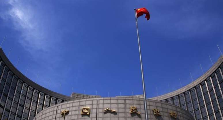 <p>Bandeira da China hasteada em frente à sede do banco central do país, em Pequim</p>