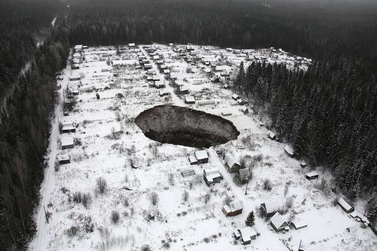 O enorme buraco é visto em imagem aérea - quatro casas foram "engolidas"