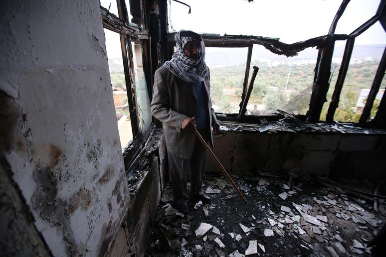 Um dos membros palestinos da casa incendiada mostra situação em que ficou o imóvel após ataque