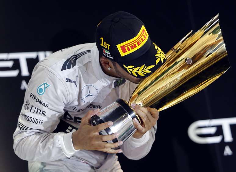 <p>Britânico beija o troféu após a conquista do GP de Abu Dhabi</p>