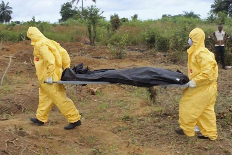 <p>Profissionais de sa&uacute;de levam o corpo de pessoa que morreu devido ao v&iacute;rus ebola em Fretown, Serra Leoa, em 21 de outubro</p>
