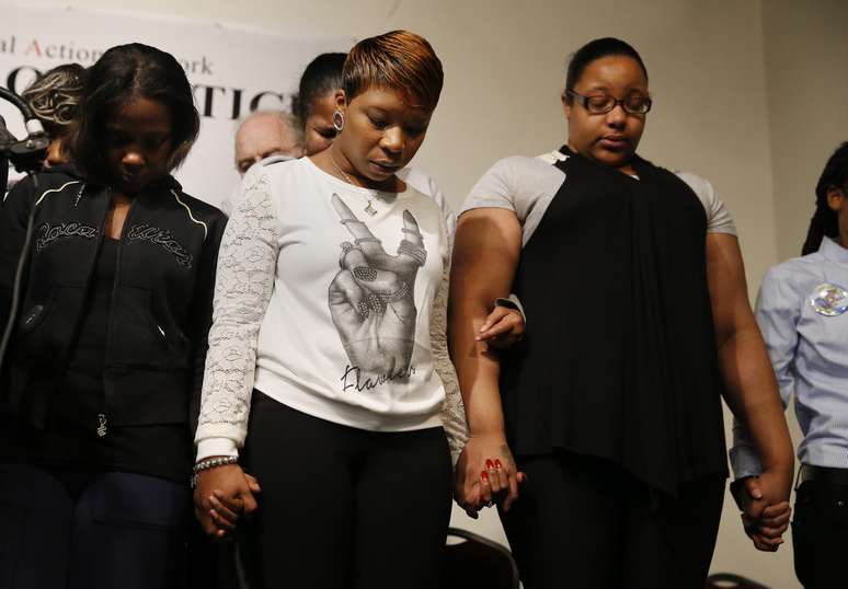 A mãe de Michael Brown (centro) faz oração com familiares de outros negros mortos pela violência policial 