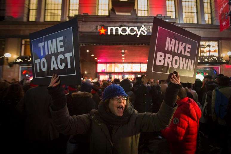 <p>Manifestantes erguem cartazes de protesto em frente a uma loja da rede Macy's, em Nova York, em apoio aos protestos em Ferguson</p>