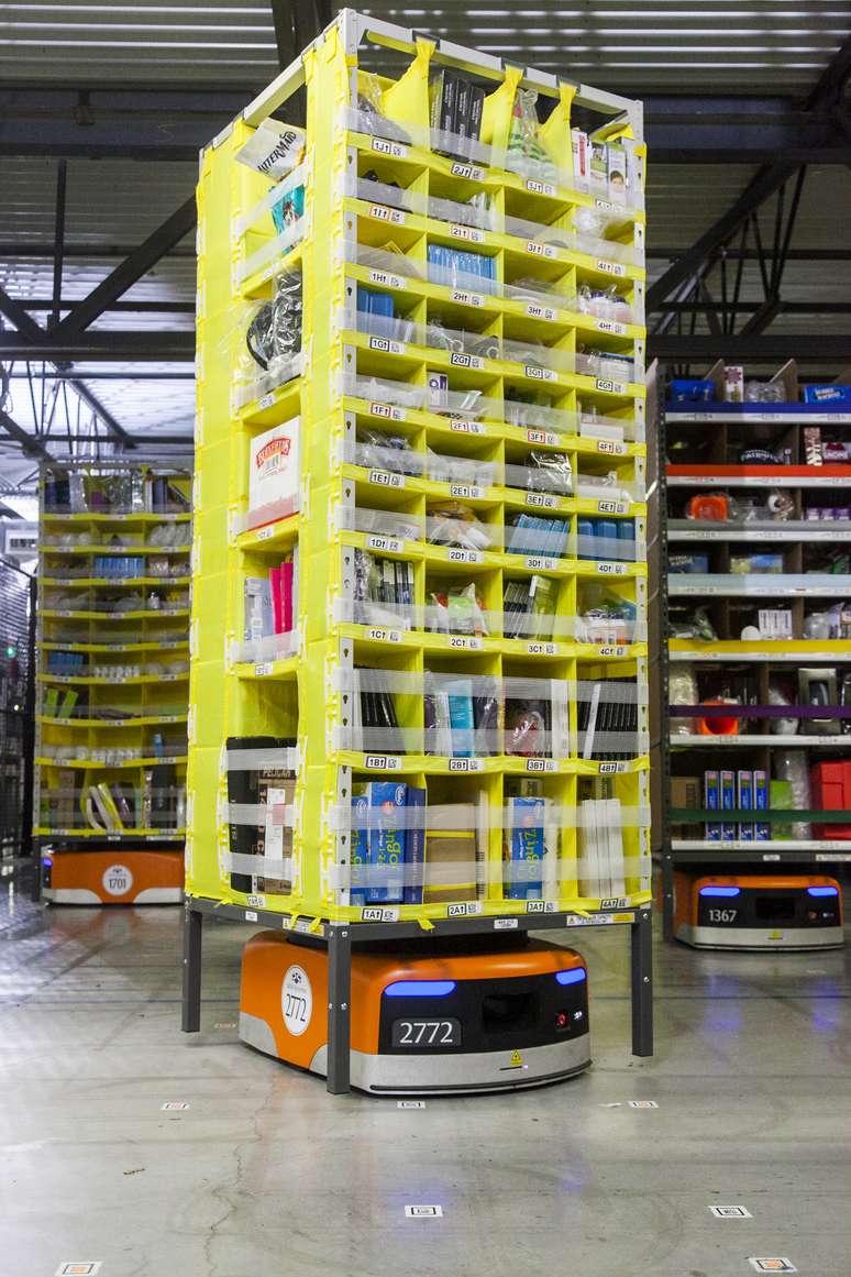 Os robôs laranjas de 145 quilos, que se movimentam sobre rodas, demonstram como a Amazon adotou a tecnologia desenvolvida pela Kiva Systems