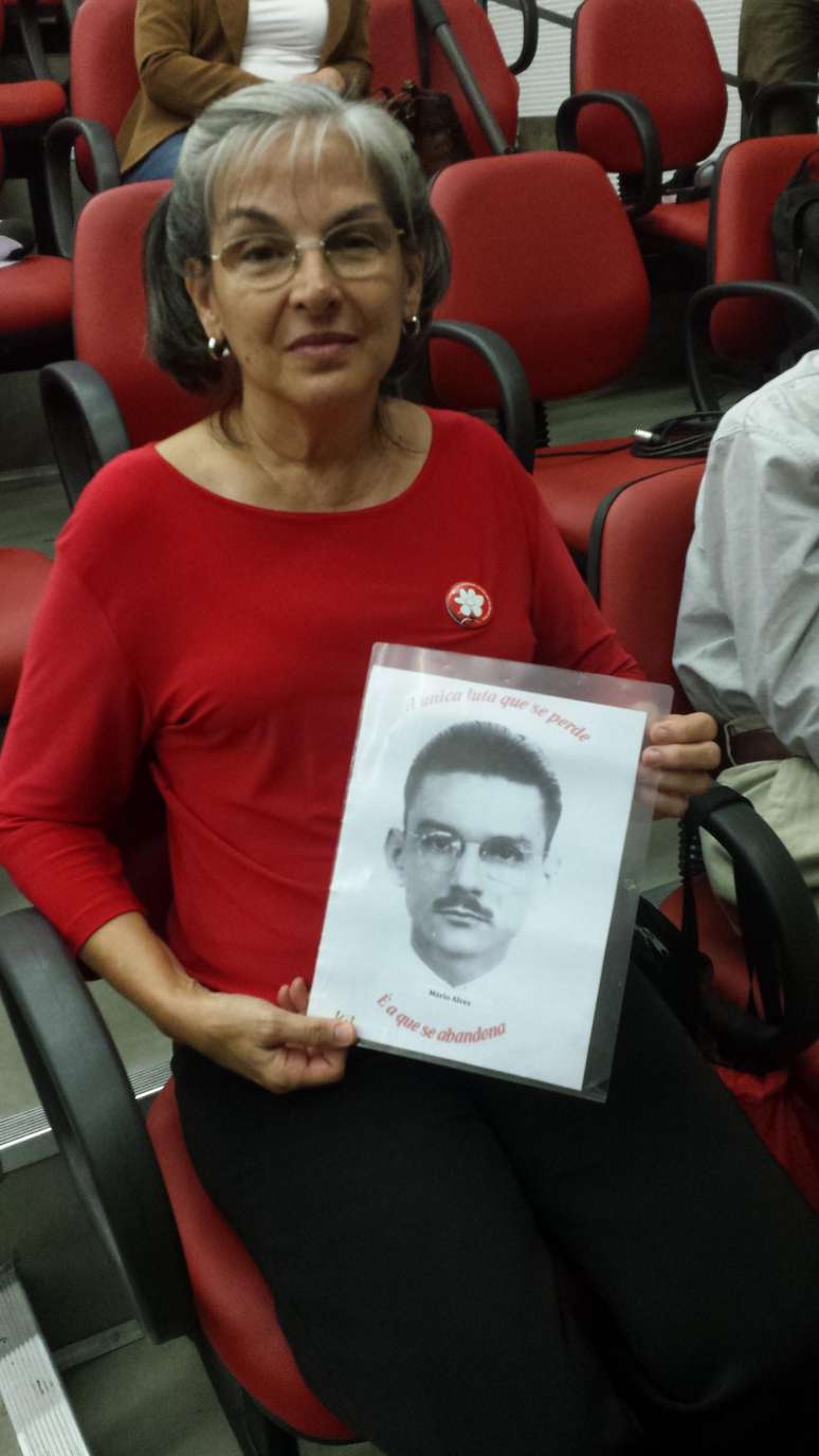 <p>L&uacute;cia Alves mostra a foto do pai,&nbsp;M&aacute;rio Alves, ex-dirigente do&nbsp;PCBR, durante&nbsp;evento realizado na Universidade do Estado do Rio de Janeiro</p>