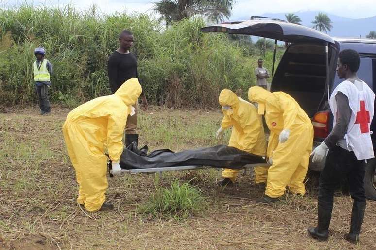 Agentes carregam corpo de vítima do Ebola em Serra Leoa. Foto de 21/10/2014.