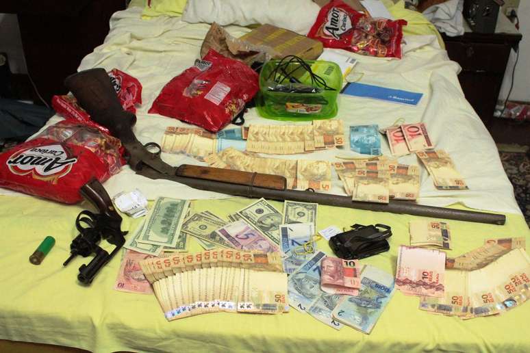 <p>A polícia encontrou armas, doces, dinheiro, computadores, CDs e DVDs na casa do suspeito</p>