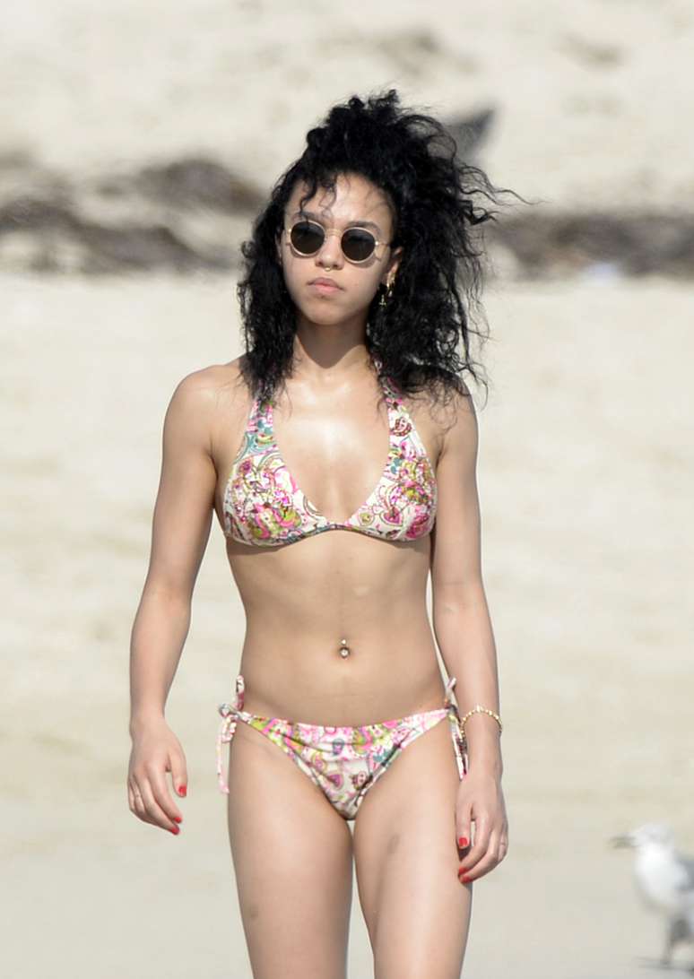 Robert Pattinson e a namorada, a cantora FKA, foram clicados enquanto curtiam um momento rom&acirc;ntico em uma praia de Miami (EUA)