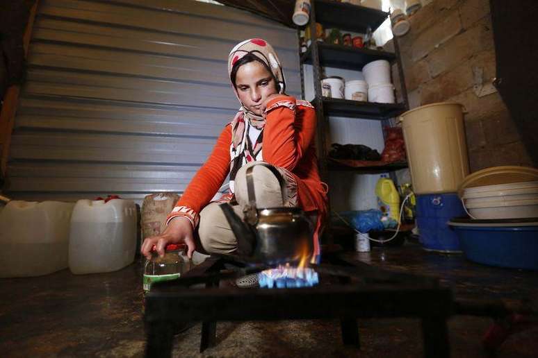 Menina síria refugiada prepara chá no campo de refugiados Al Zaatari, em Mafraq, na Jordânia, perto da fronteira com a Síria, no fim de semana. 07/12/2014