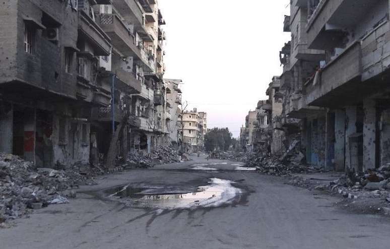 <p>Rua deserta tomada por escombros de prédios destruídos em Deir al-Zor, na Síria, em março deste ano</p>