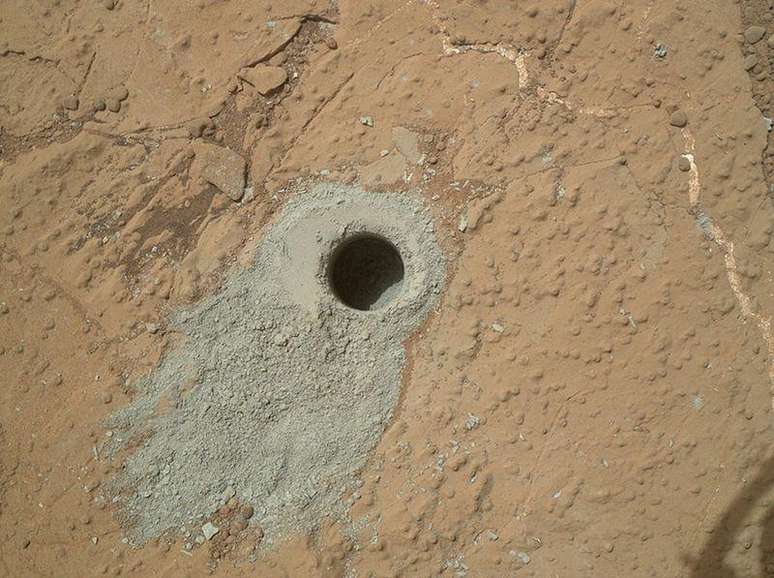 <p>O ve&iacute;culo explorador Curiosity perfura rocha em Marte, em maio</p>