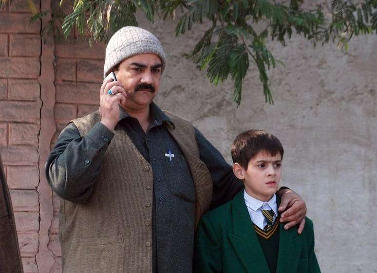 Homem vai buscar um garoto em uma escola militar que foi atacada por homens armados do Taliban em Peshawar, no Paquistão. 16/12/2014.