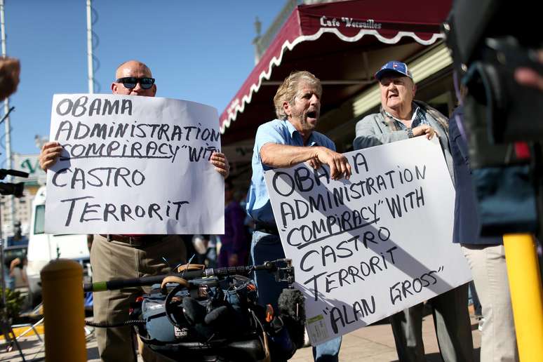 <p>Osvaldo Hernadez, Miguel Saavedra e Carlos Munoz Fontanillehas (da esquerda para a direita) reagem à notícia, fora do restaurante Little Havana Versalhes, em Miami (EUA), de que Alan Gross foi libertado de uma prisão cubana dezembro</p>