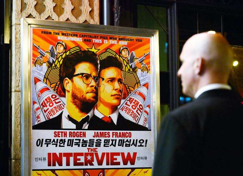 Segurança na entrada de um cinema em frente ao pôster do filme "A Entrevista", em Los Angeles. 11/12/2014