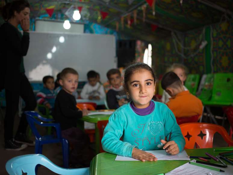 Menina sorri em escola no Iraque