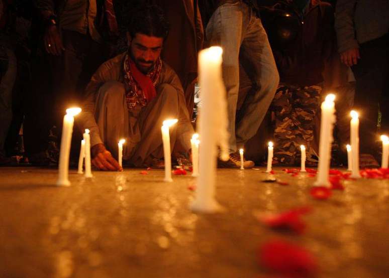 Homem acende vela durante vigília em homenagem às vítimas do ataque contra uma escola militar paquistanesa, em Carachi, no Paquistão. 16/12/2014.