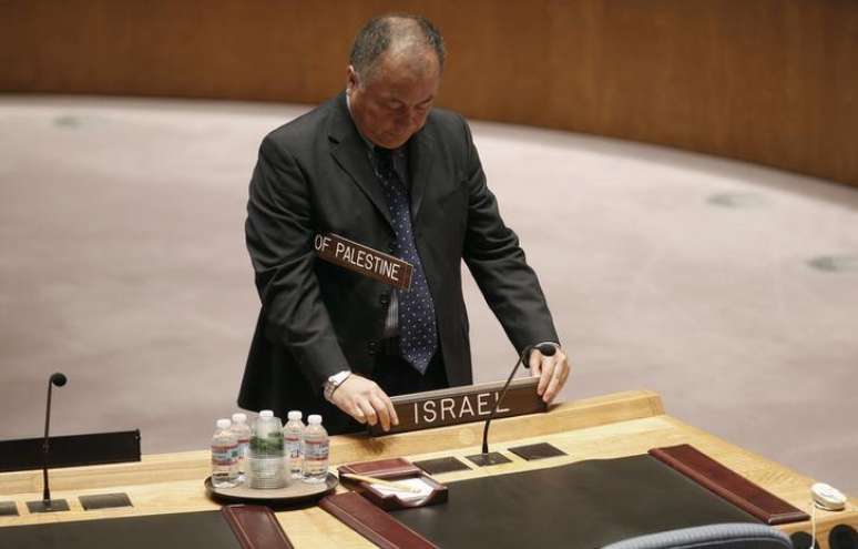 Homem coloca placas sinalizando os assentos de Israel e dos territórios palestinos antes de uma reunião do Conselho de Segurança na sede da ONU, em Nova York. 31/07/2014.