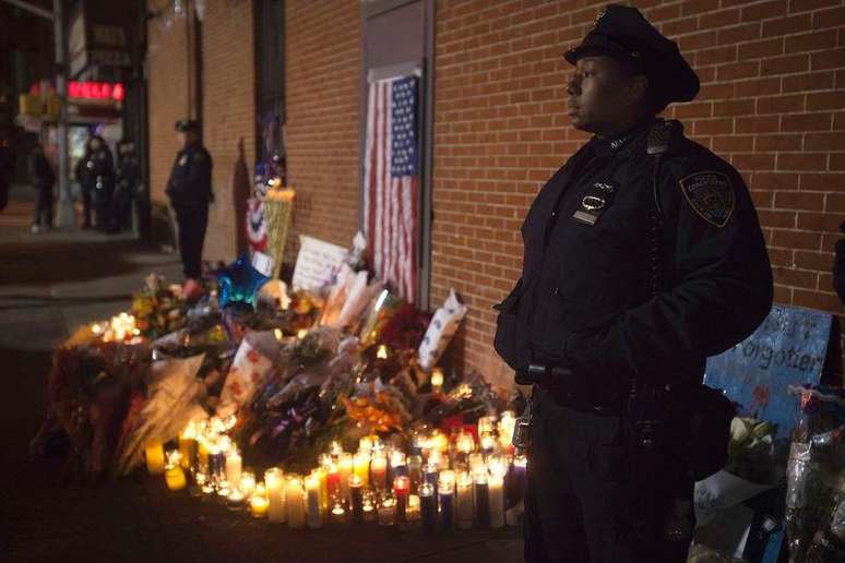 Policiais montem guarda no local em que foi montada uma vigília improvisada, onde dois policiais foram mortos a tiros, no Brooklin, em Nova York. 21/12/2014.