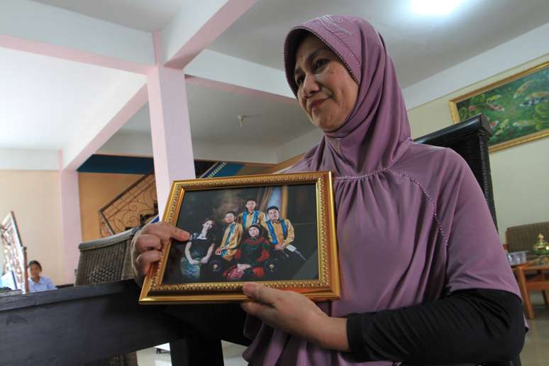 Mulher mostra foto de parentes desaparecidos em voo