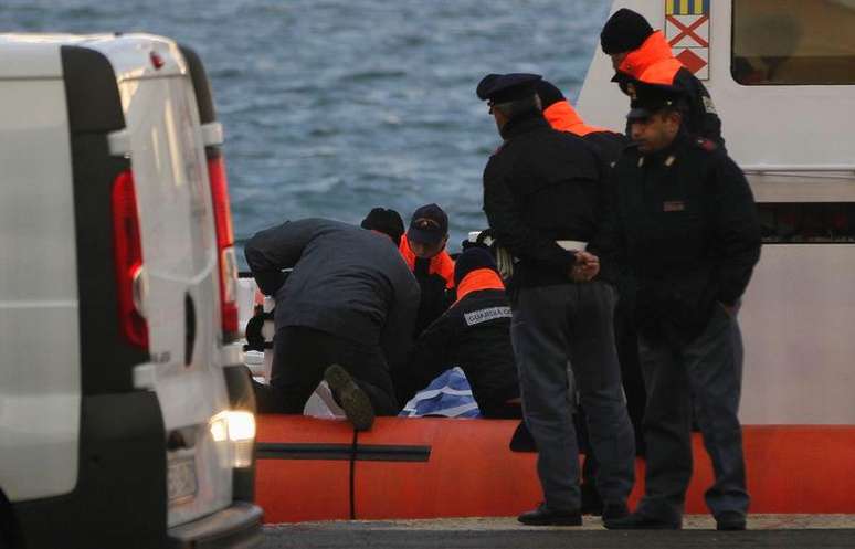 <p>Equipe da guarda costeira italiana carrega um corpo após chegada ao porto</p>