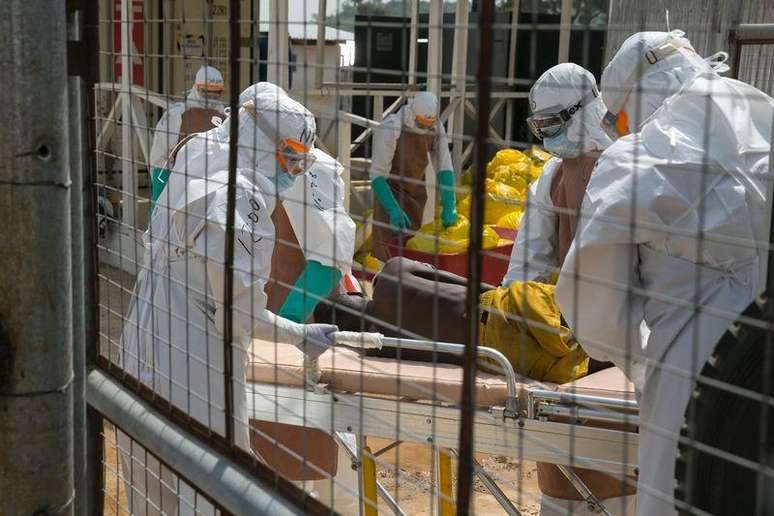 <p>Agentes de saúde tratam de pacientes com Ebola perto de Freetown, Serra Leoa</p>