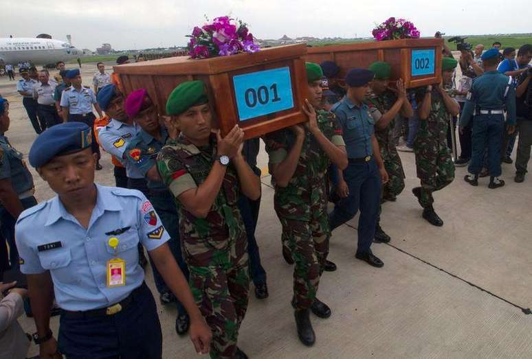 <p>Militares da Indon&eacute;sia carrega caix&otilde;es com os corpos de duas v&iacute;timas da queda do avi&atilde;o da AirAsia, em Surabaya, na Indon&eacute;sia, nesta quarta-feira</p>