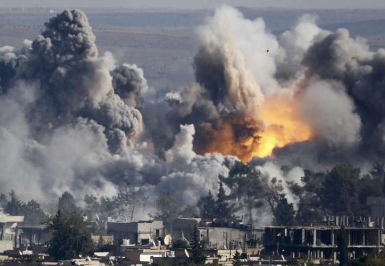 Fumaça se ergue no local de um ataque aéreo, na cidade síria de Kobani, perto da fronteira com a Turquia. 18/10/2014.