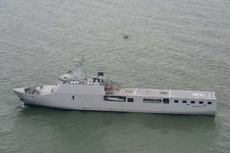 Helicóptero sobrevoa mar de Java em buscas pelos restos do voo AirAsia perto de navio da Marinha do país
