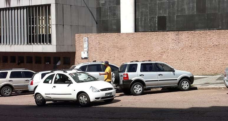 Flanelinha cobra de veículo estacionado em região com parquímetro