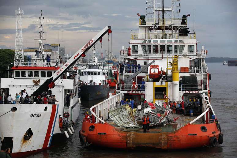 Equipes de resgate transportam a cauda da aeronave da AirAsia após ela ser resgatada do Mar de Java, em 10 de janeiro