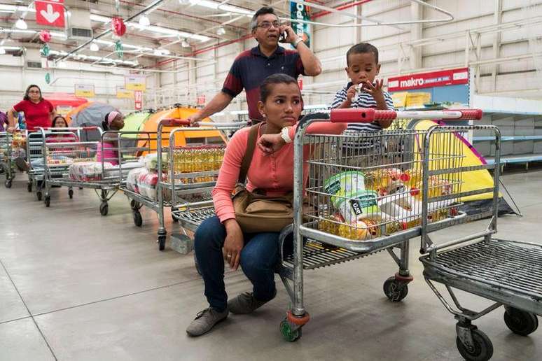 Pessoas fazem filas para pagar compras em supermercado de Caracas. 09/01/2015