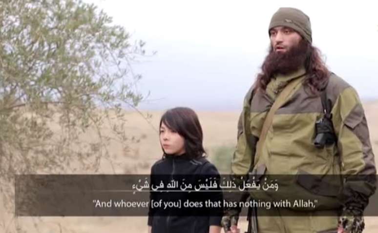 O menino aparece do lado de um jihadista adulto que fala por alguns segundos 