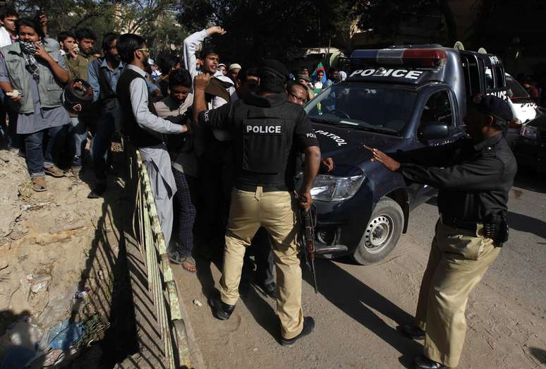 Policiais tentam conter manifestantes em Karachi, no Paquistão, que protestavam contra a revista satírica Charlie Hebdo