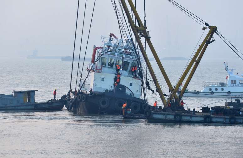 Equipes de resgate se aproximam dos destroços do barco rebocador que naufragou no rio Yangtze, na China