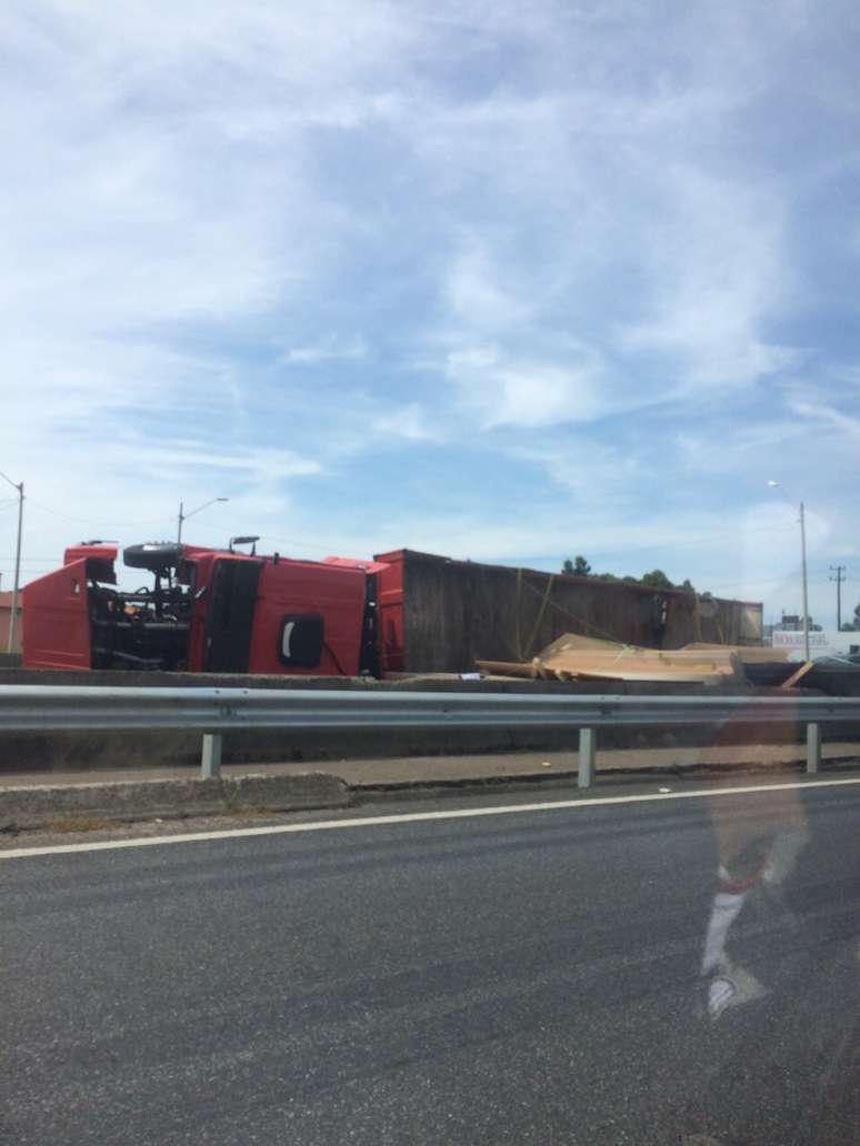 Itajaí, 18/1 - Um caminhão carregado de madeira tombou na BR-101, próximo à ponte de Navegantes; o acidente em Santa Catarina deixou duas pessoas feridas e interditou as pistas da rodovia