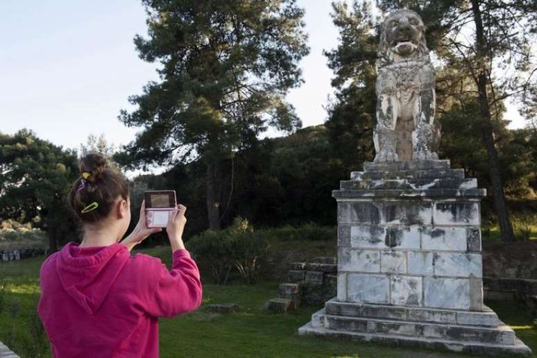 Menina tira foto de leão de mármore perto de local de escavação arqueológica na cidade de Amphipolis, no norte da Grécia. 22/11/2014