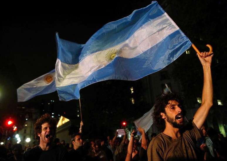 Manifestantes gritam frases e exibem bandeiras argentinas durante protesto sobre a morte do promotor Alberto Nisman, no lado de fora da Casa Rosada, em Buenos Aires, na Argentina, na segunda-feira. 19/01/2015