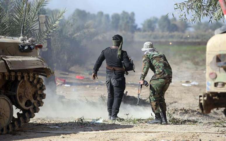 <p>Combatentes iraquianos enfrentam homens do Estado Islâmico em Al-Nibai, a norte de Bagdá</p>