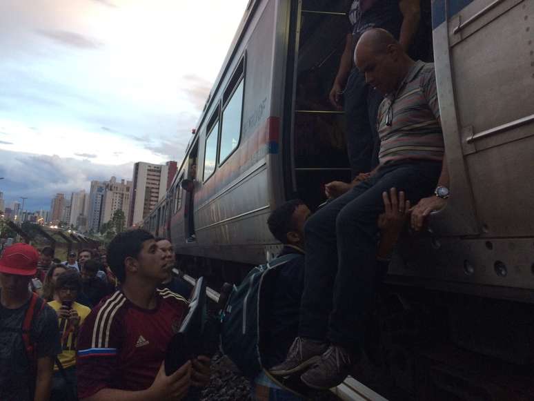 <p>Passageiros se ajudam no momento de descer do trem</p>