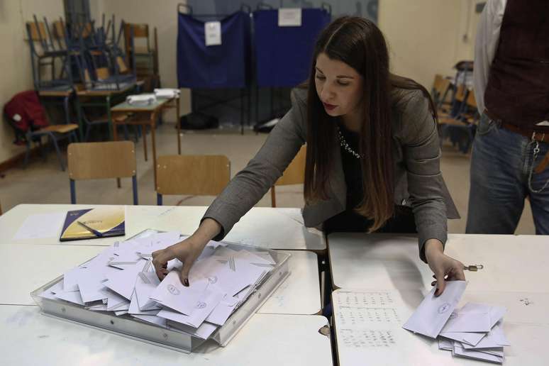 Funcionária conta cédulas em local de votação em Atenas, neste domingo